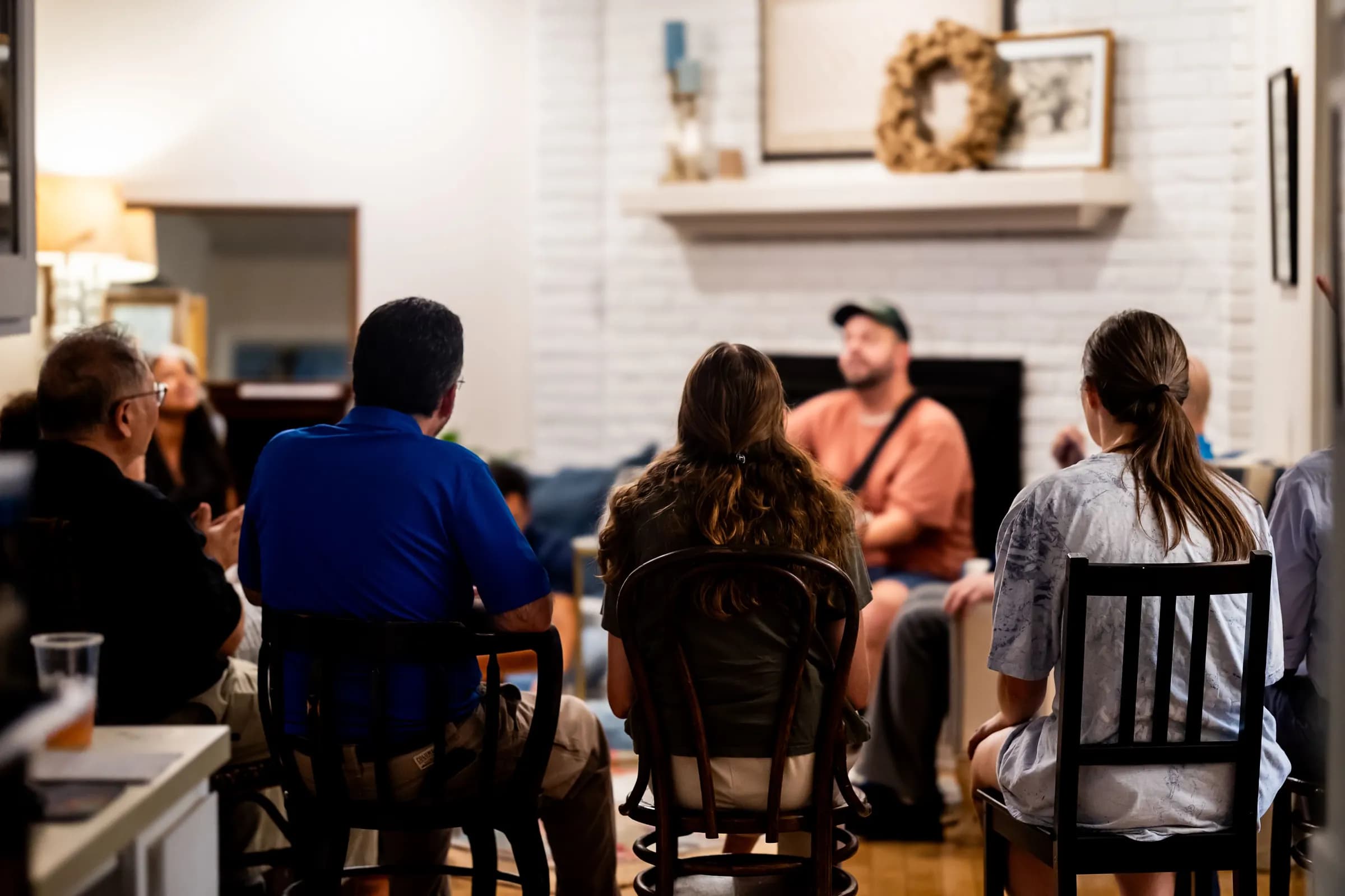 Residents and staff gathered for an evening meeting in a recovery home living room